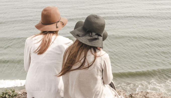 海を眺める二人の女性の後ろ姿